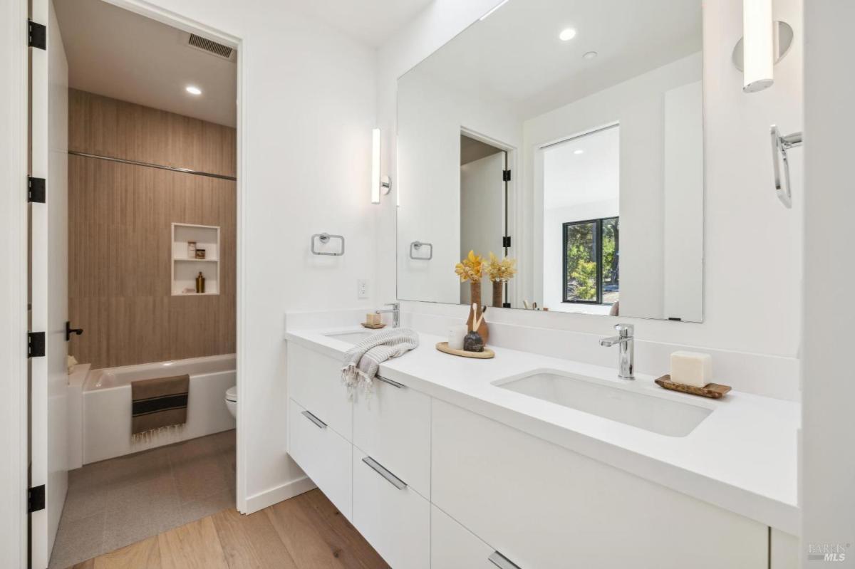 A bathroom with a white vanity and a shower-tub combo.