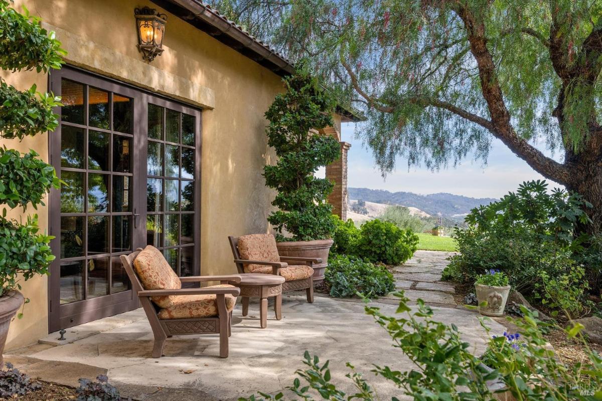 A small patio with two chairs and a table outside a house.