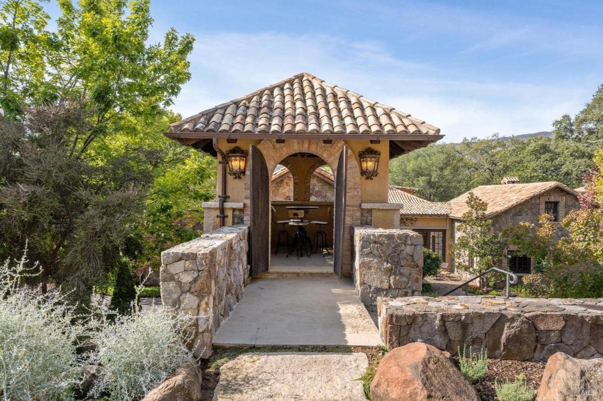 A small gazebo-style structure with a tiled roof and seating inside.