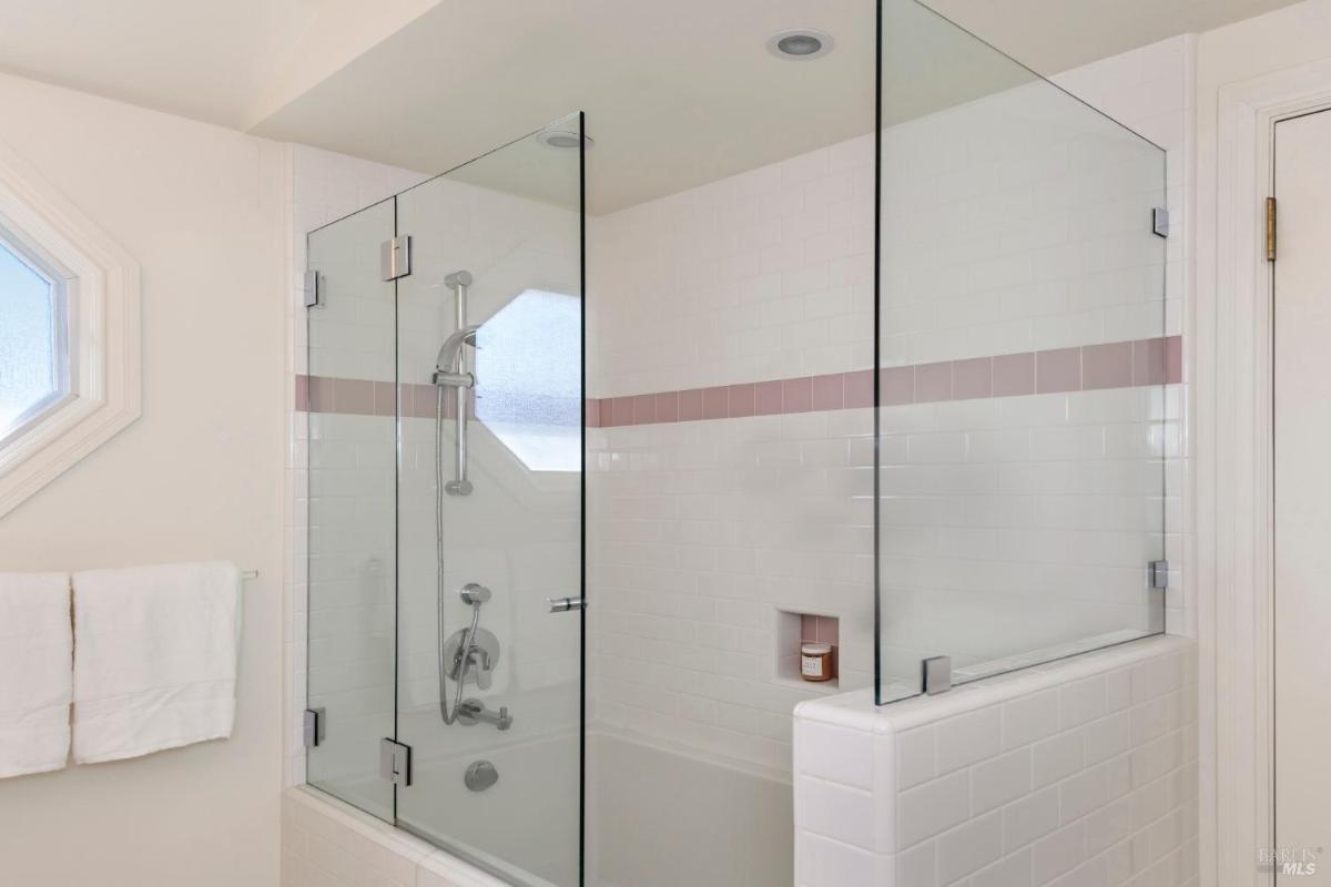 Bathroom with a glass-enclosed shower, tiled walls, and a built-in niche.