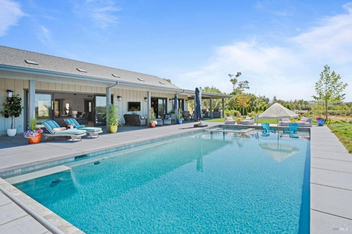 large rectangular swimming pool with a view of the trees and mountain.