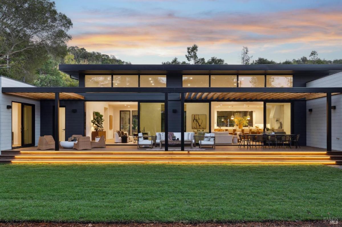 Modern home exterior with symmetrical windows and a landscaped yard.