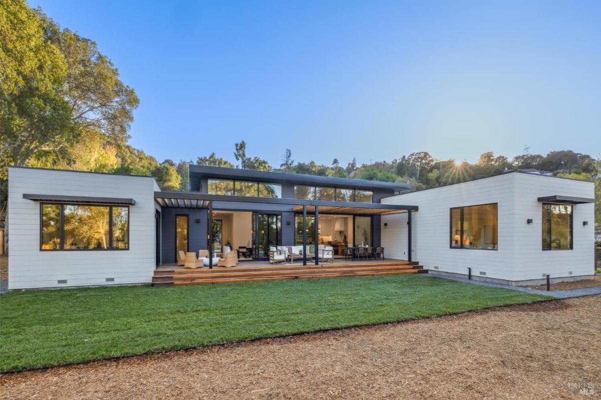 Modern home exterior with symmetrical windows and a landscaped yard.