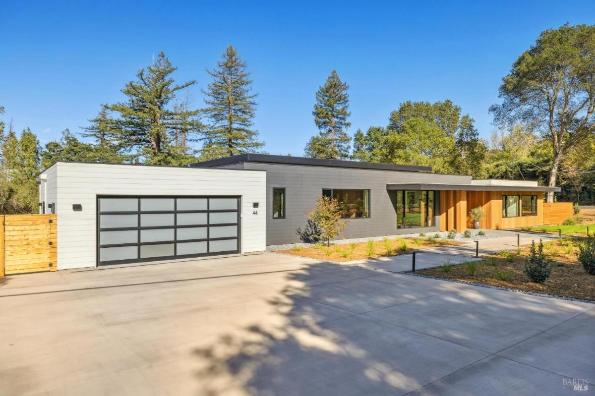 Driveway leading to a garage attached to a modern one-story house.