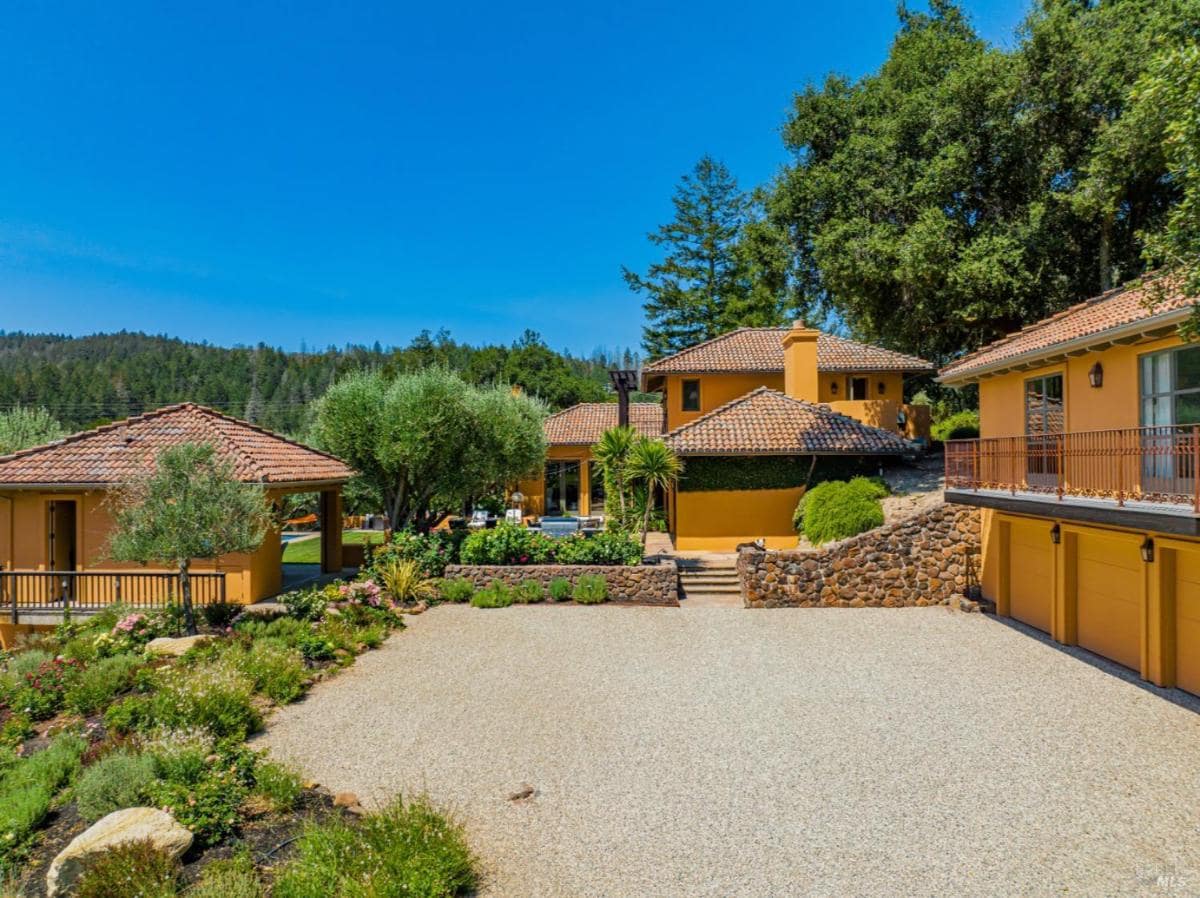 House exterior with multiple structures and a driveway.
