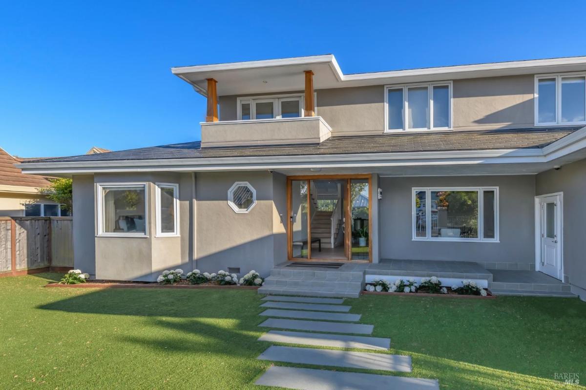 Exterior view of a two-story home with a lawn and modern entry.