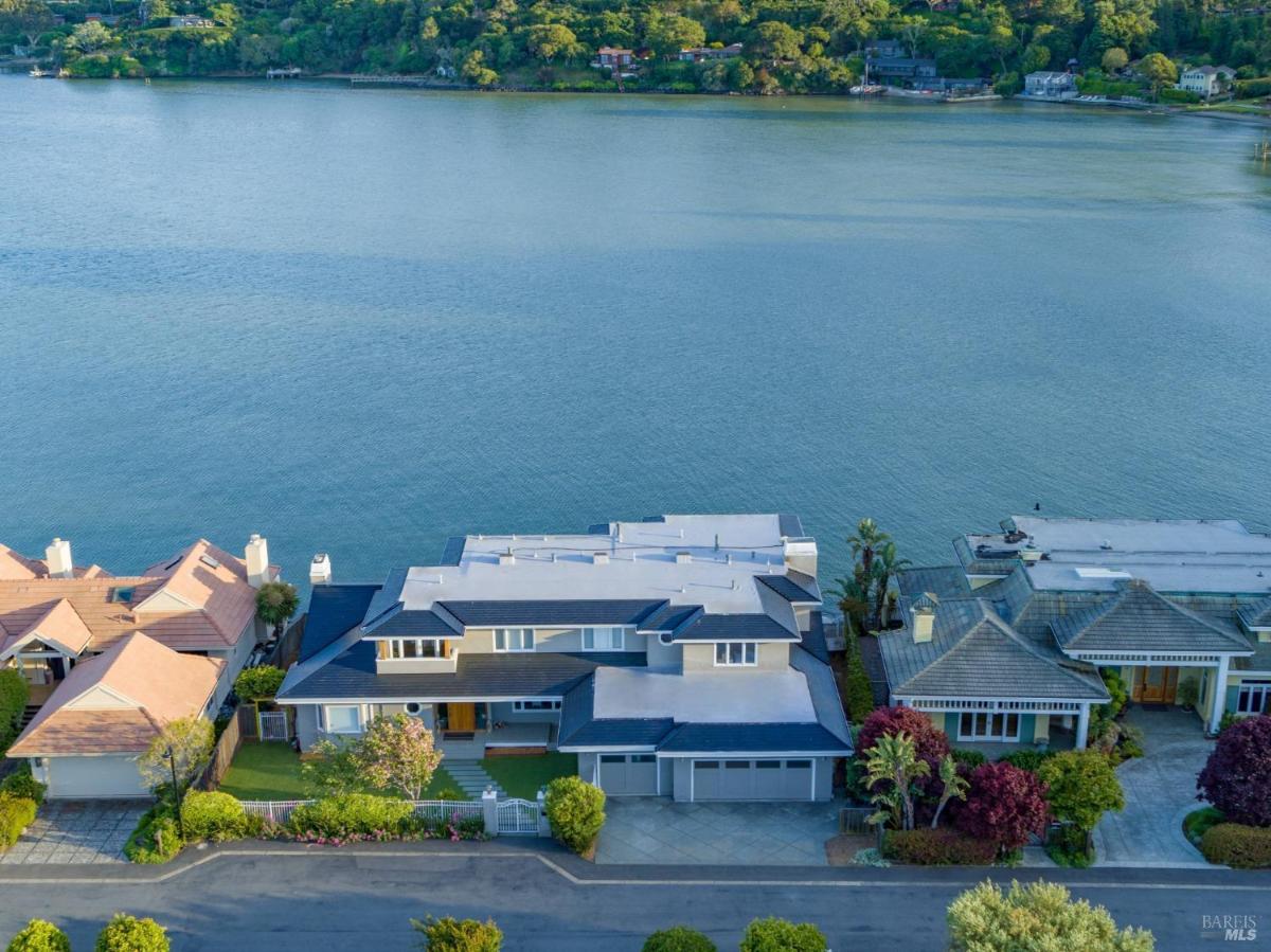 Aerial view of a waterfront home next to other houses.