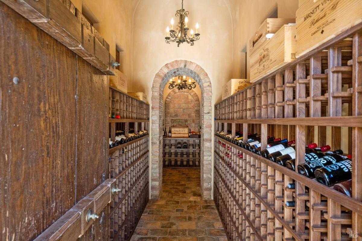Wine cellar with brick walls and wooden wine racks.