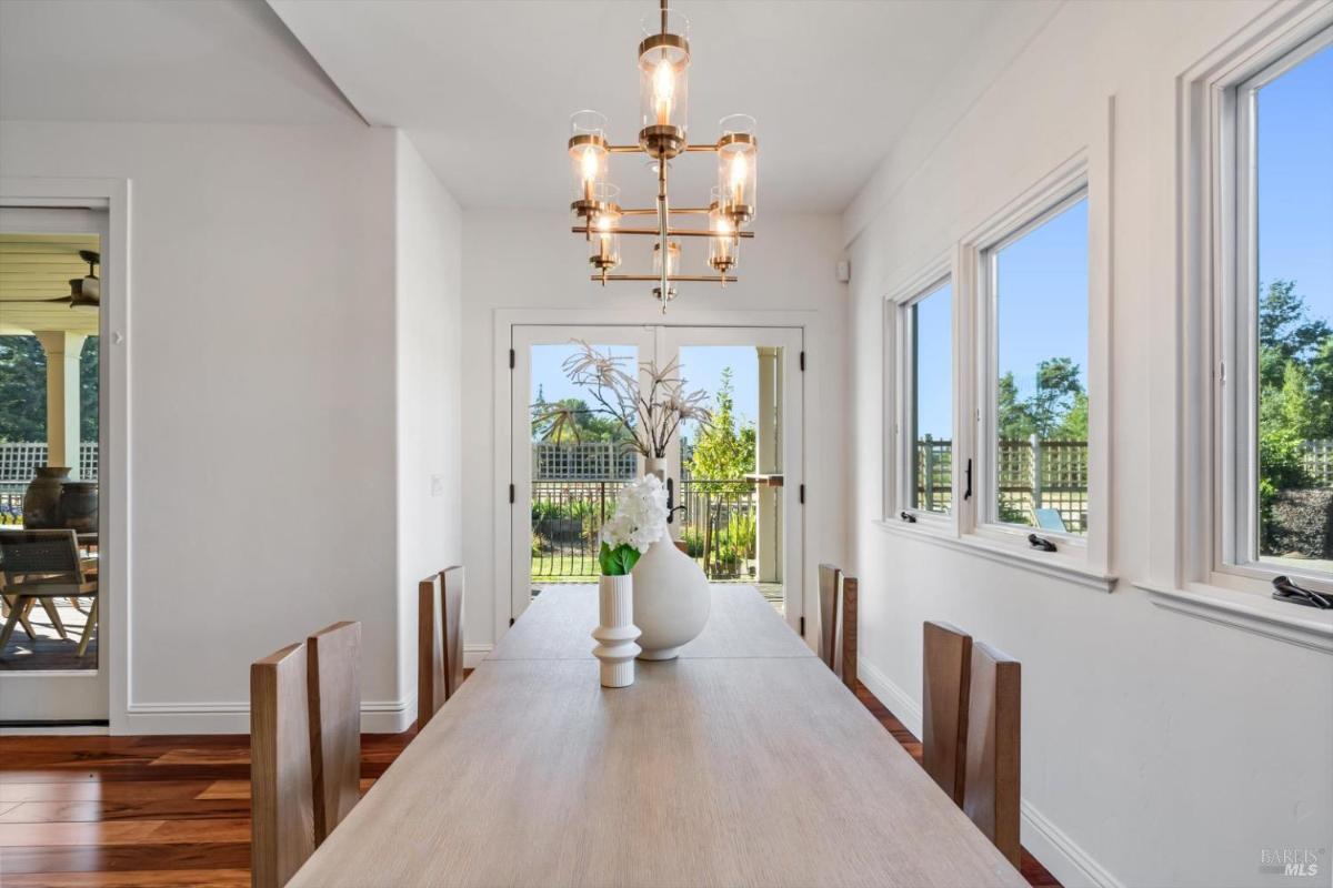 Dining room with a table, chairs, and a chandelier near a garden door.