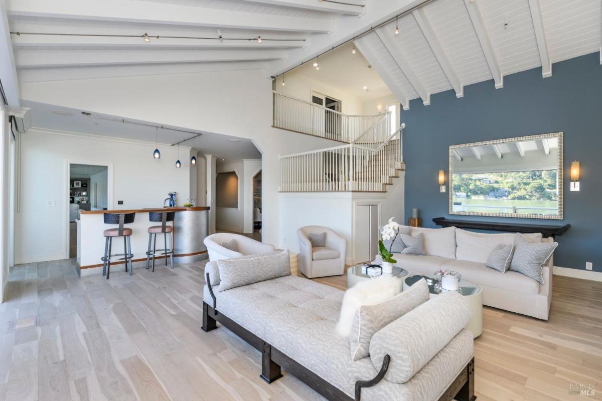 Living area with seating and a staircase to the second floor.