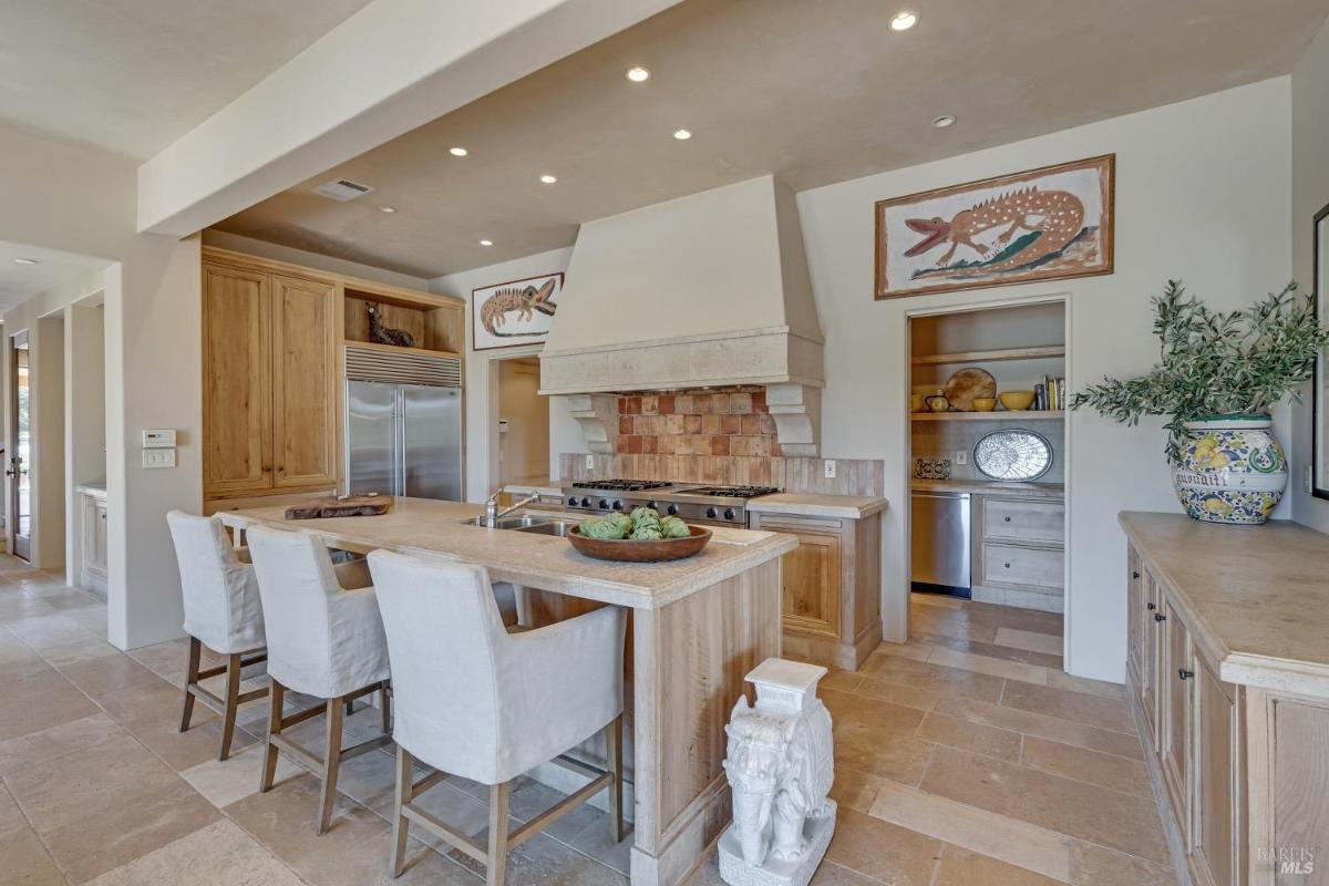 Kitchen with a central island, built-in appliances, and a range hood.