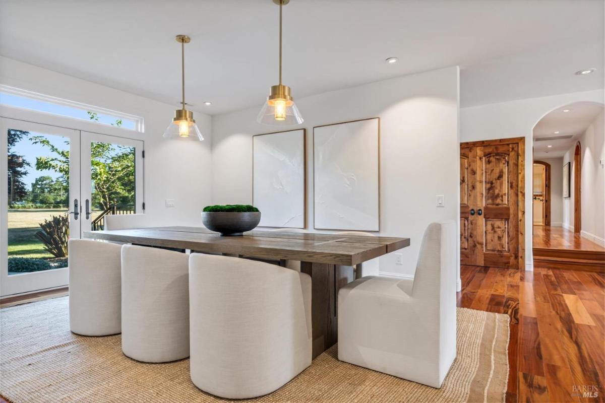 Formal dining space with a table, cushioned chairs, and decorative elements.