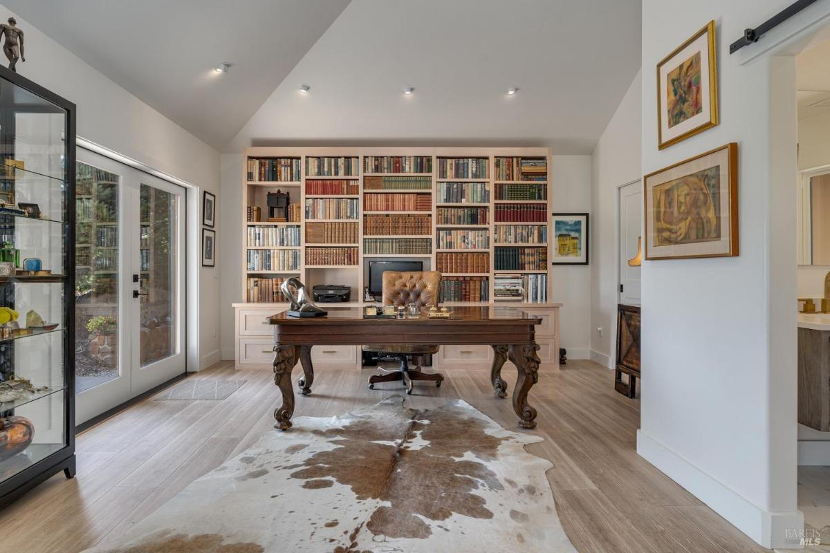 Home office with built-in bookshelves, a desk, and a sliding glass door.