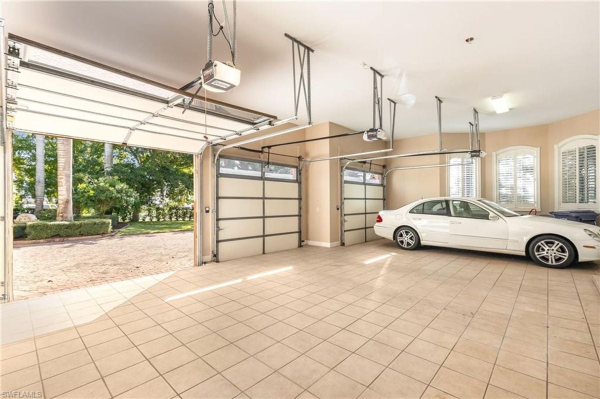 Car garage with tiled flooring, natural light streaming through windows, and automated doors offering easy access to the outdoors.
