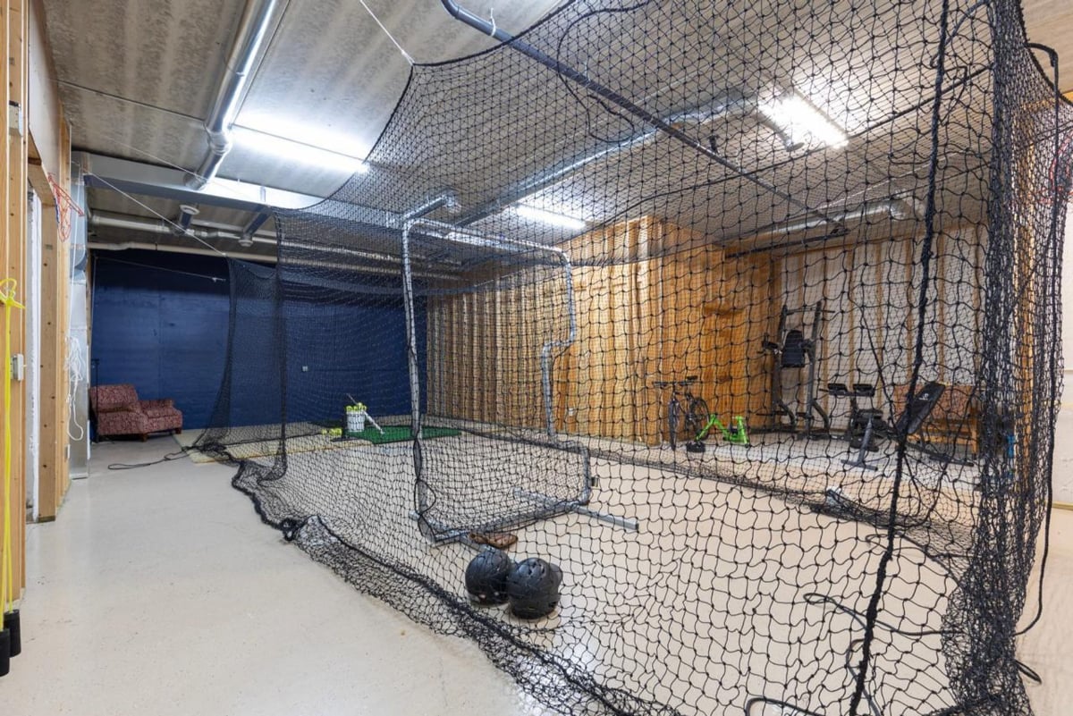 Batting cages and exercise equipment are enclosed in a spacious indoor training area.