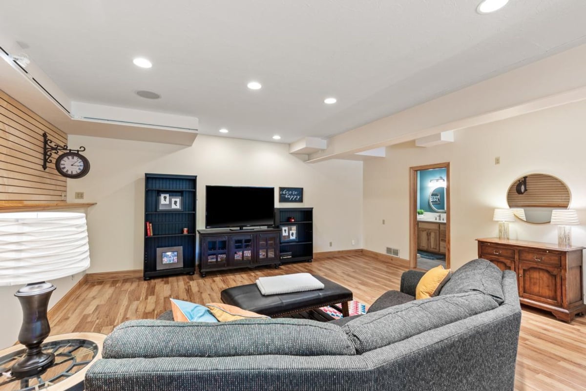 Hardwood floors, a large sectional sofa, and an entertainment center create a comfortable and spacious family room.