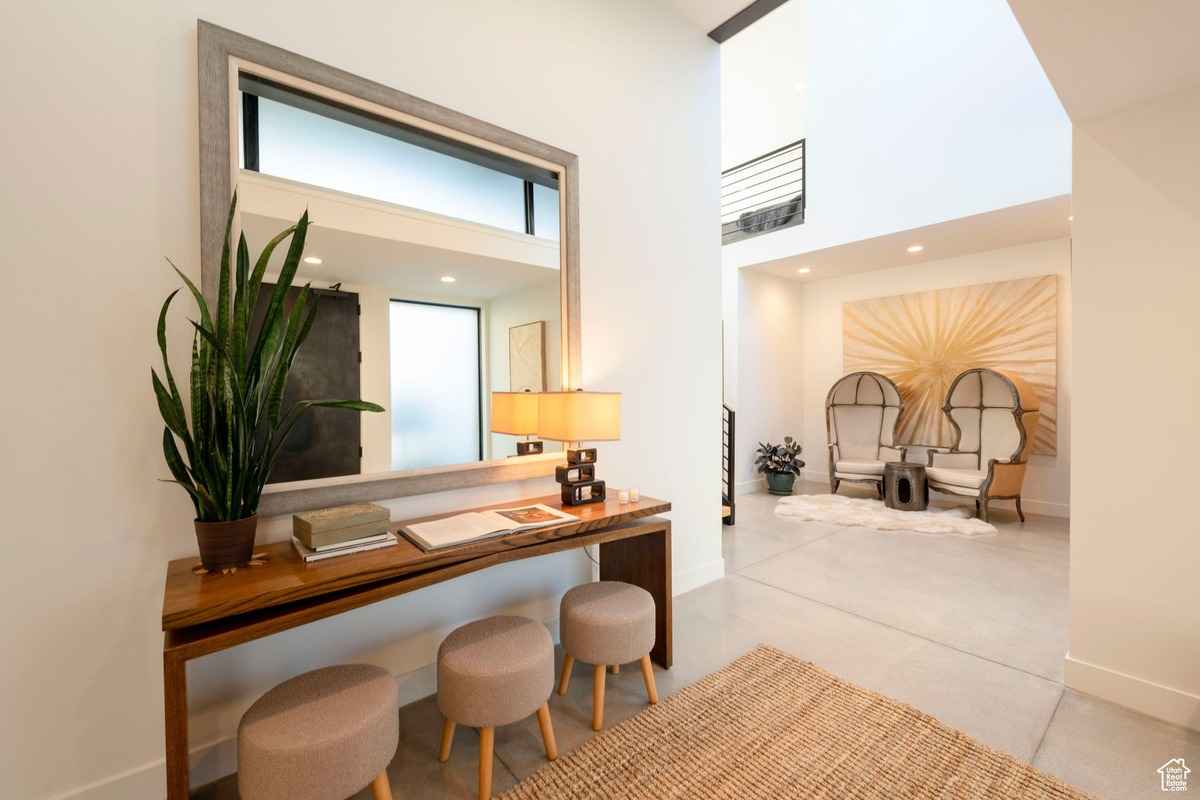 A stylish interior featuring a wooden console table, a large mirror, and cozy seating.