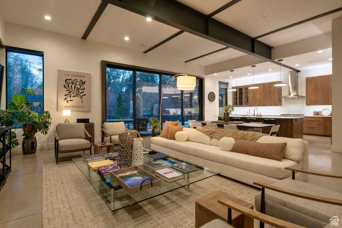 A cozy living area with stylish decor, large glass doors, and an adjacent open kitchen.