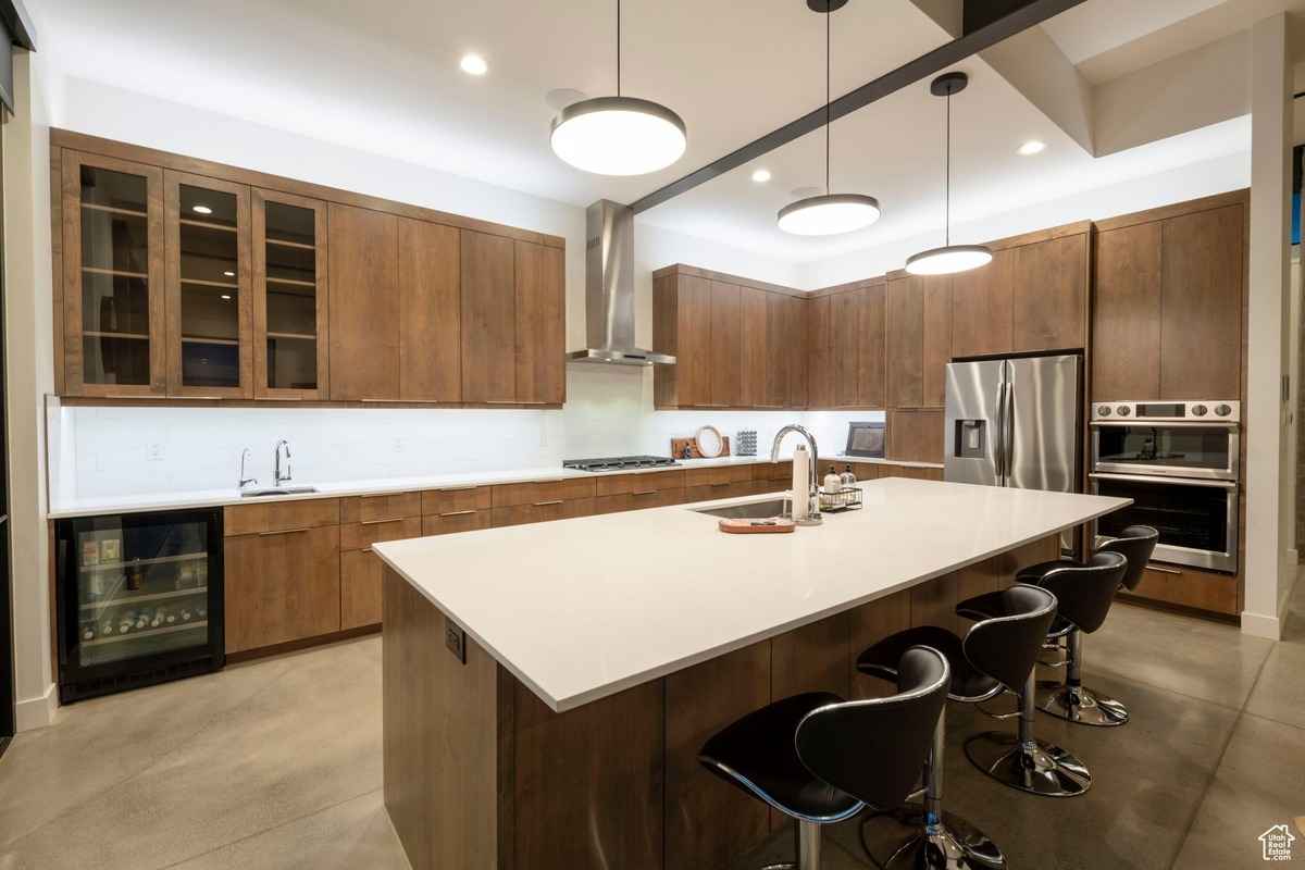 A large modern kitchen featuring a central island with bar seating and pendant lighting.