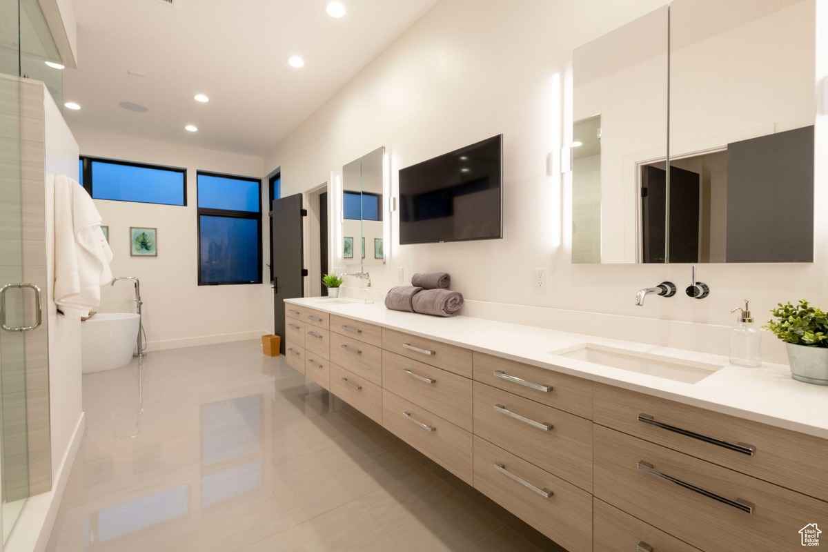 A modern bathroom with a double vanity, large mirrors, and bright lighting.