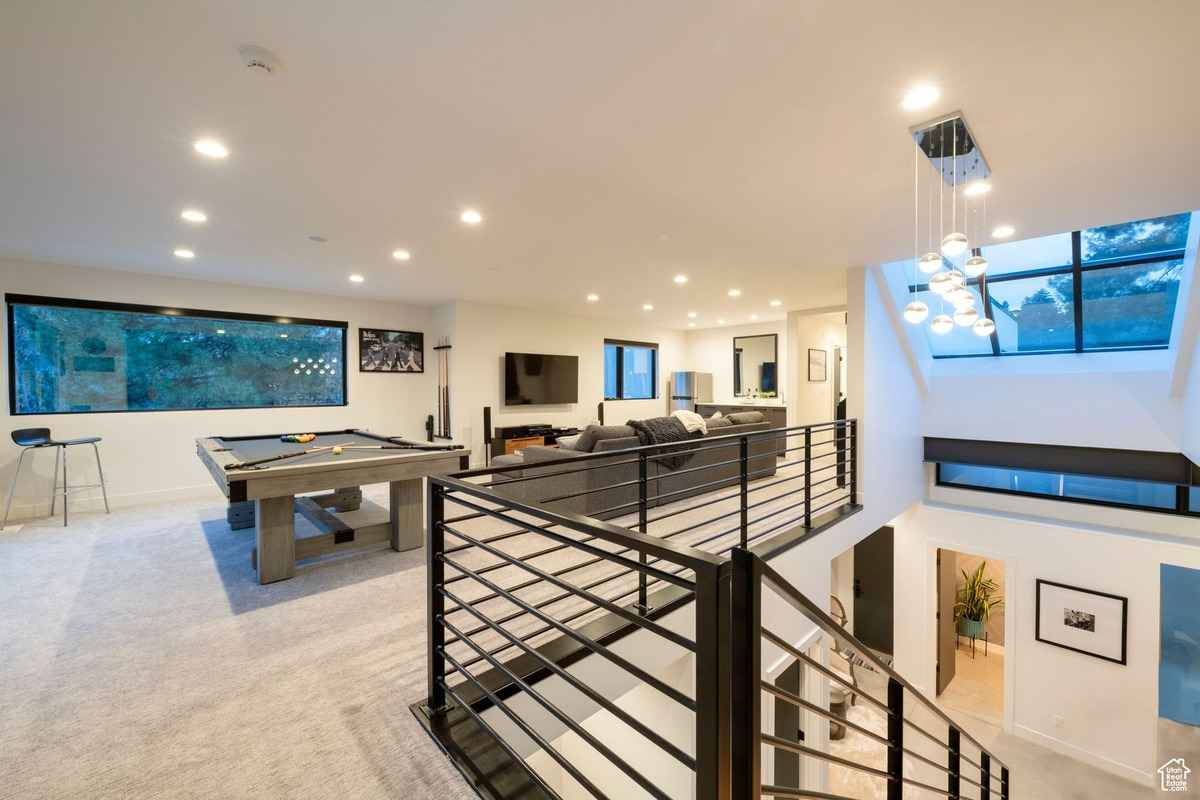 An upstairs game room and lounge area with a pool table and ample seating.