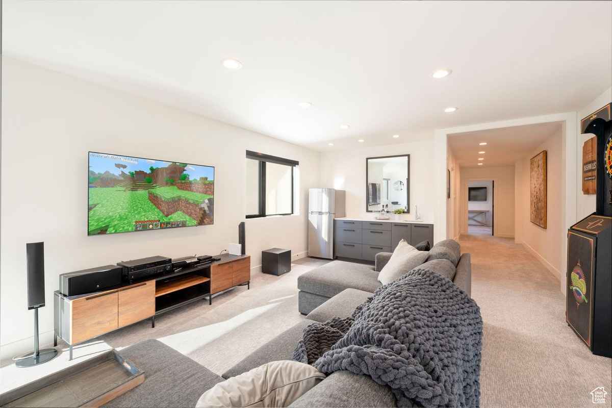A contemporary lounge with a large TV and sleek furnishings.