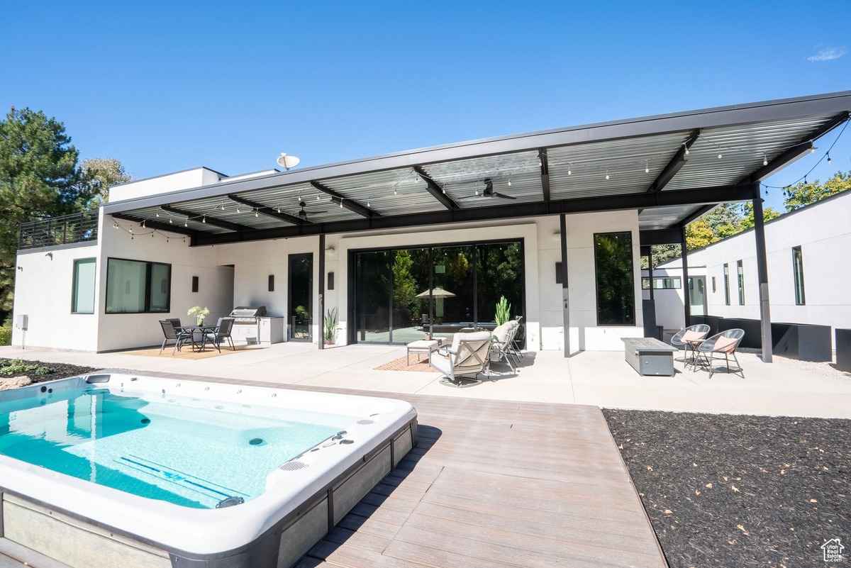 A backyard view featuring a hot tub and patio area.
