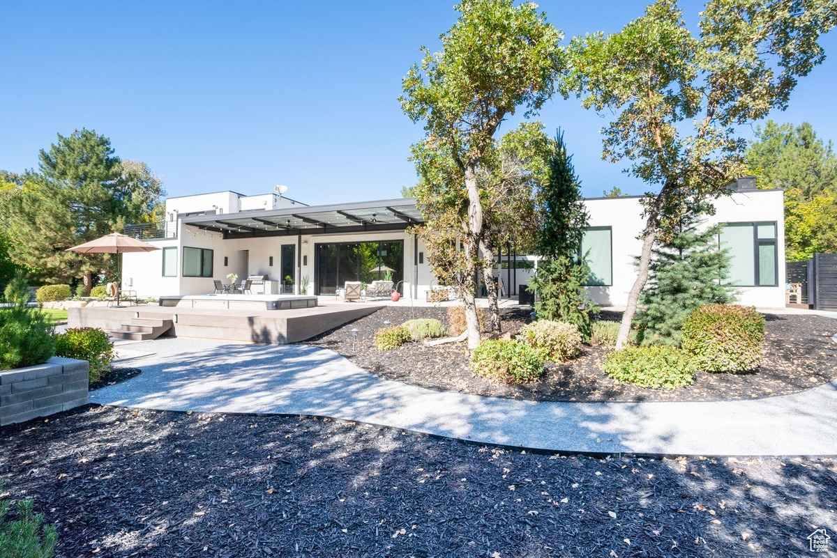 A modern backyard with a sleek patio, minimalistic landscaping, and a spacious deck.
