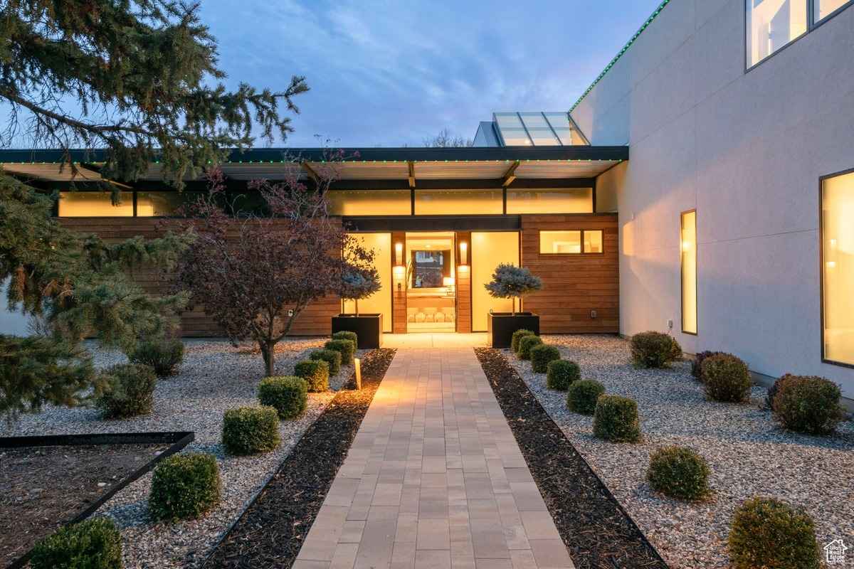 An illuminated entrance of the house at night with warm lighting and frosted glass panels.