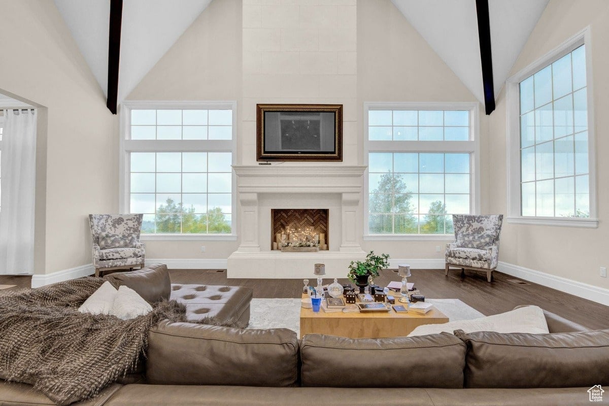 This stunning living room showcases a harmonious blend of modern comfort and classic style. Floor-to-ceiling windows offer panoramic views, while the fireplace and seating arrangement create a warm and inviting atmosphere.