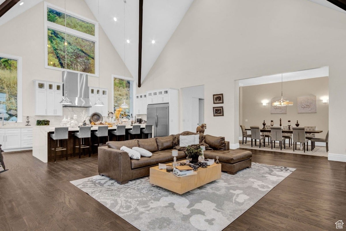 This open-concept living area seamlessly blends a modern kitchen with a spacious living room, creating a fluid and inviting atmosphere. Large windows and high ceilings maximize natural light, while the neutral color palette enhances the sense of spaciousness.