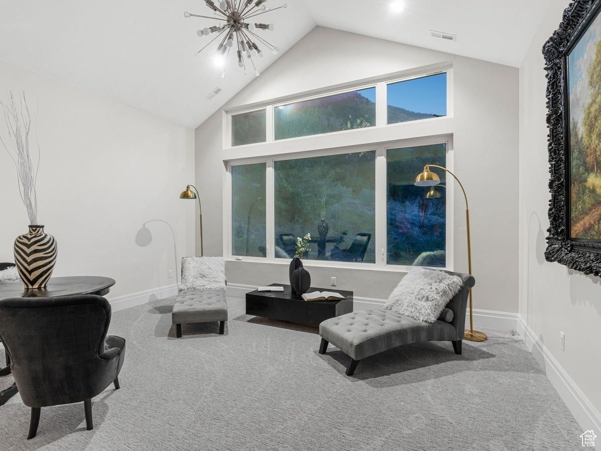 Two chaise lounges are positioned to enjoy the expansive window view in this relaxing sitting area, creating a tranquil and luxurious atmosphere. A unique light fixture and elegant décor complete the sophisticated design of this room.