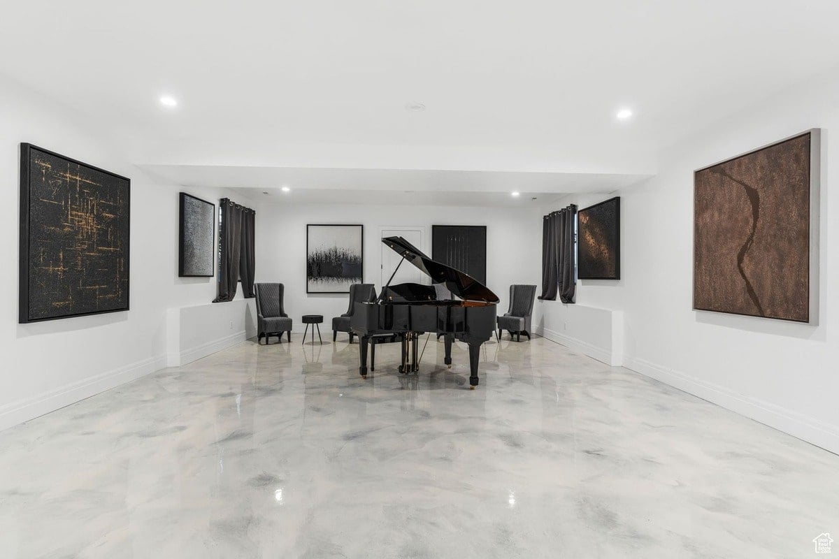 A minimalist interior design is highlighted, with a grand piano placed prominently in a room with several pieces of abstract art. The polished concrete floor and clean lines create a spacious and sophisticated ambiance.