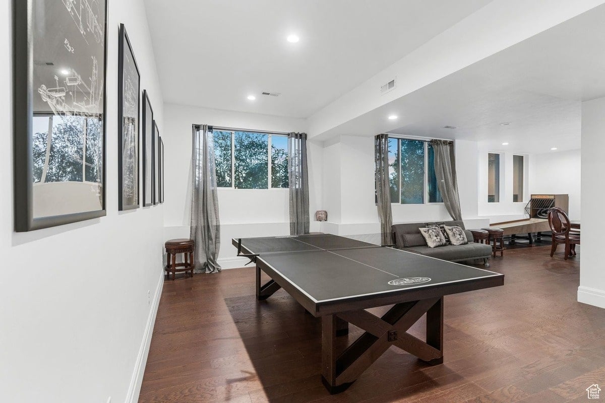 A game room or recreation area is shown, featuring a large, high-quality ping pong table as the focal point. The hardwood floors and neutral walls create a clean and inviting atmosphere for leisure and entertainment.
