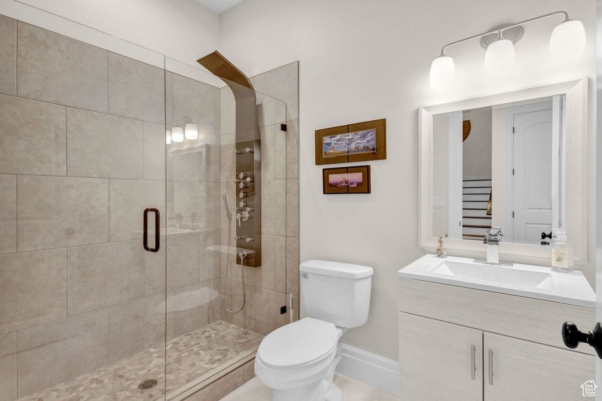 A contemporary bathroom is presented, featuring a frameless glass shower with a multi-function showerhead and a modern vanity. The neutral color palette and clean lines create a spa-like atmosphere in this well-designed space.