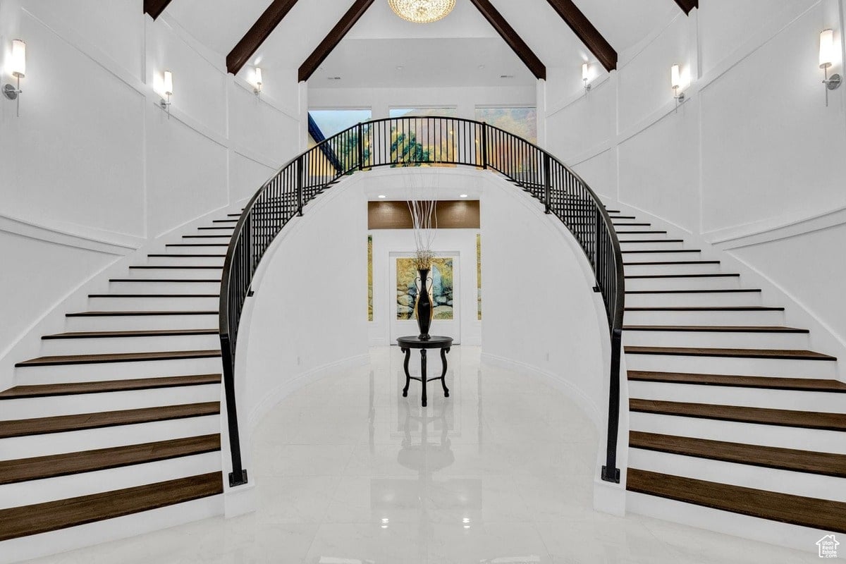 A breathtaking view of a home's entryway is captured in this photograph, with twin curved staircases forming a dramatic focal point. The contrast between the dark wood and the bright white walls enhances the architectural impact of this impressive feature.