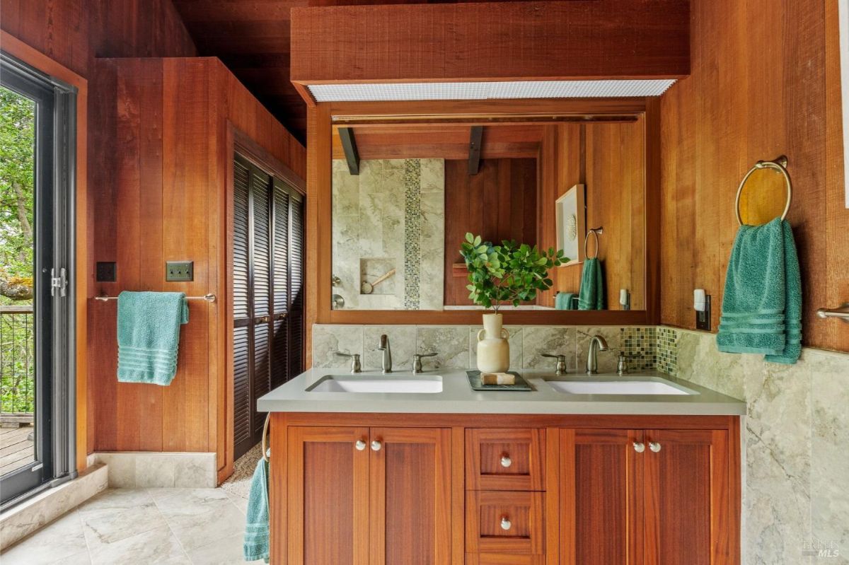 Bathroom features a wooden vanity with double sinks, tiled walls, and green accents.