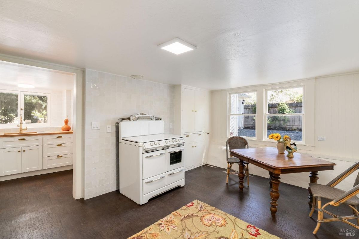 Kitchen or prep area with a vintage oven and a small dining table.