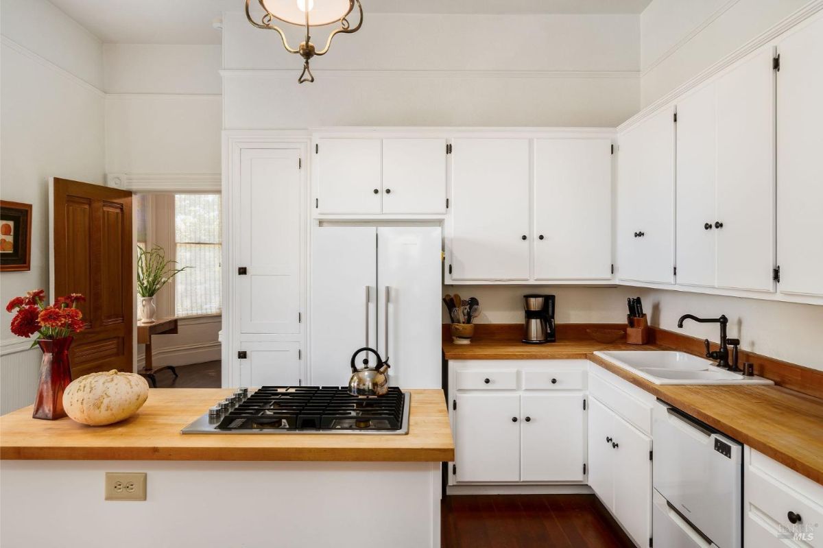 Kitchen angle highlighting the refrigerator, countertops, and cabinetry.