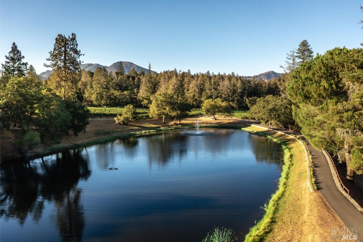A serene lake surrounded by lush greenery and majestic mountains, offering a peaceful retreat amidst nature's beauty.