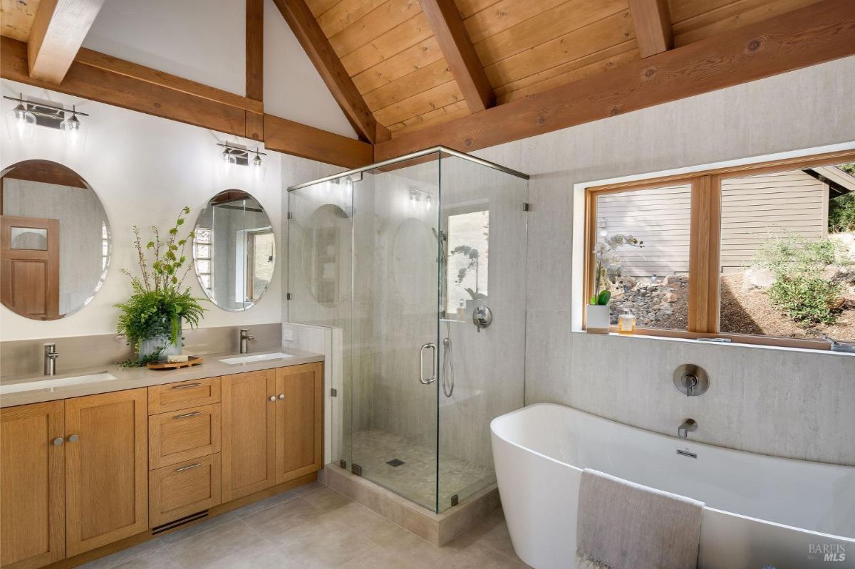Bathroom featuring vaulted wooden ceiling, double vanity, shower, and bathtub.
