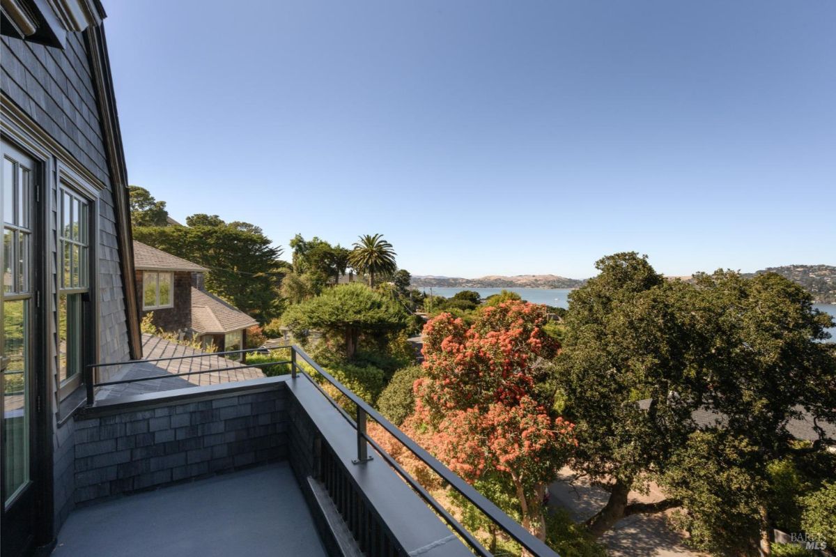 Balcony overlooks trees and water.