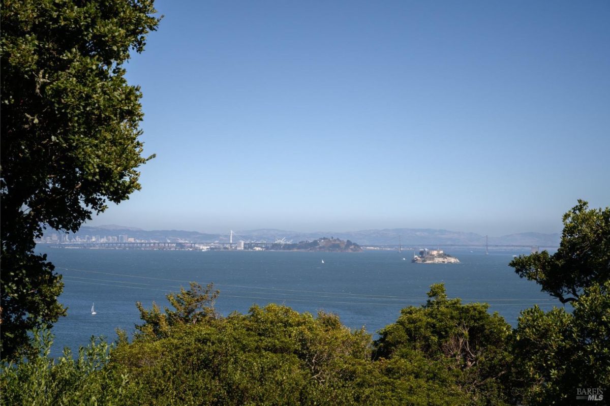 View from balcony shows water, islands, and city skyline in the distance.