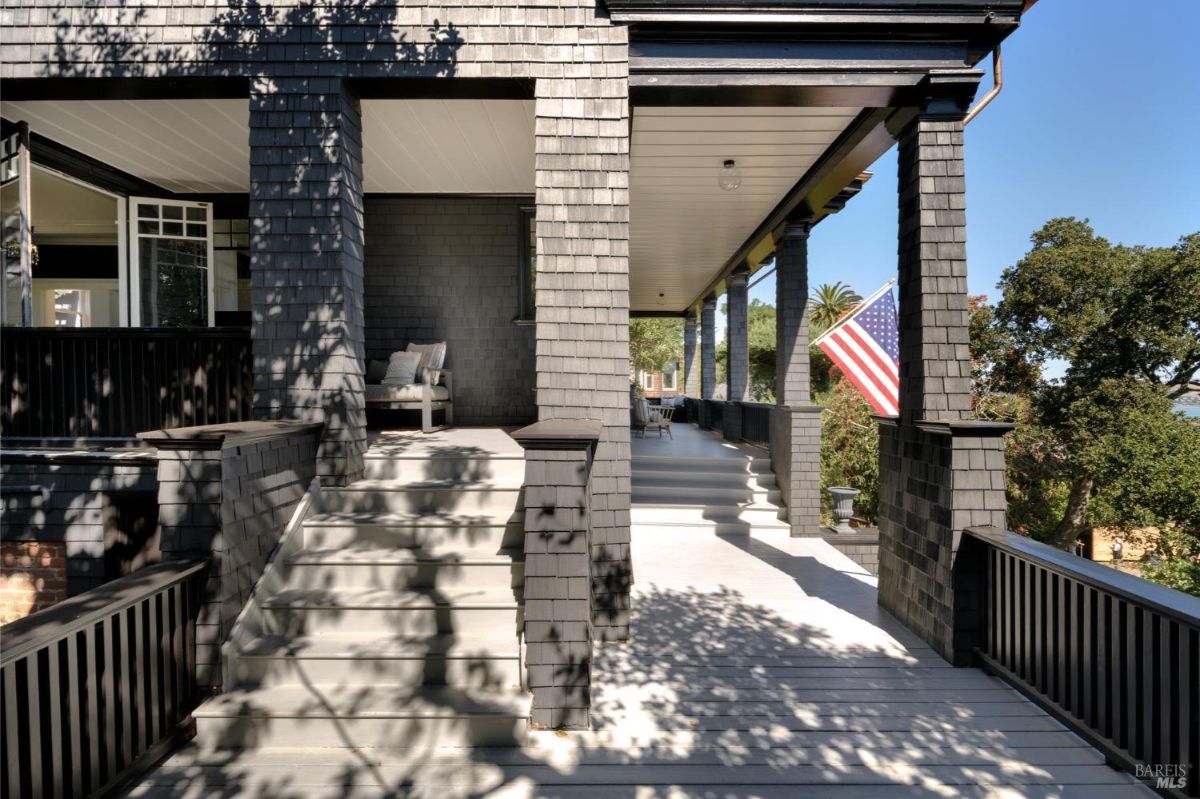 Front porch with a white-painted floor and an American flag on display.