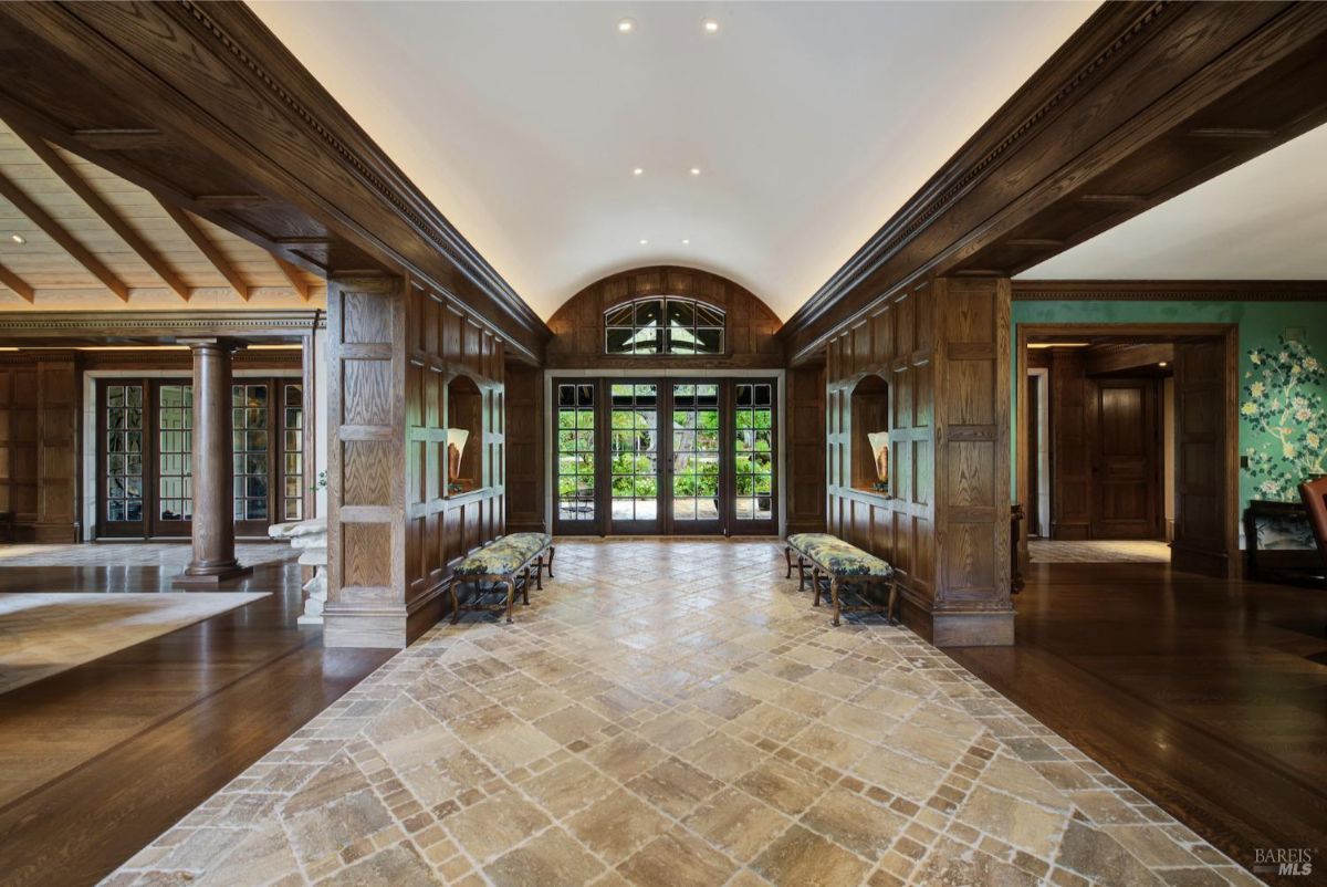 A luxurious foyer with wood-paneled walls and intricate flooring, exuding warmth and grandeur.