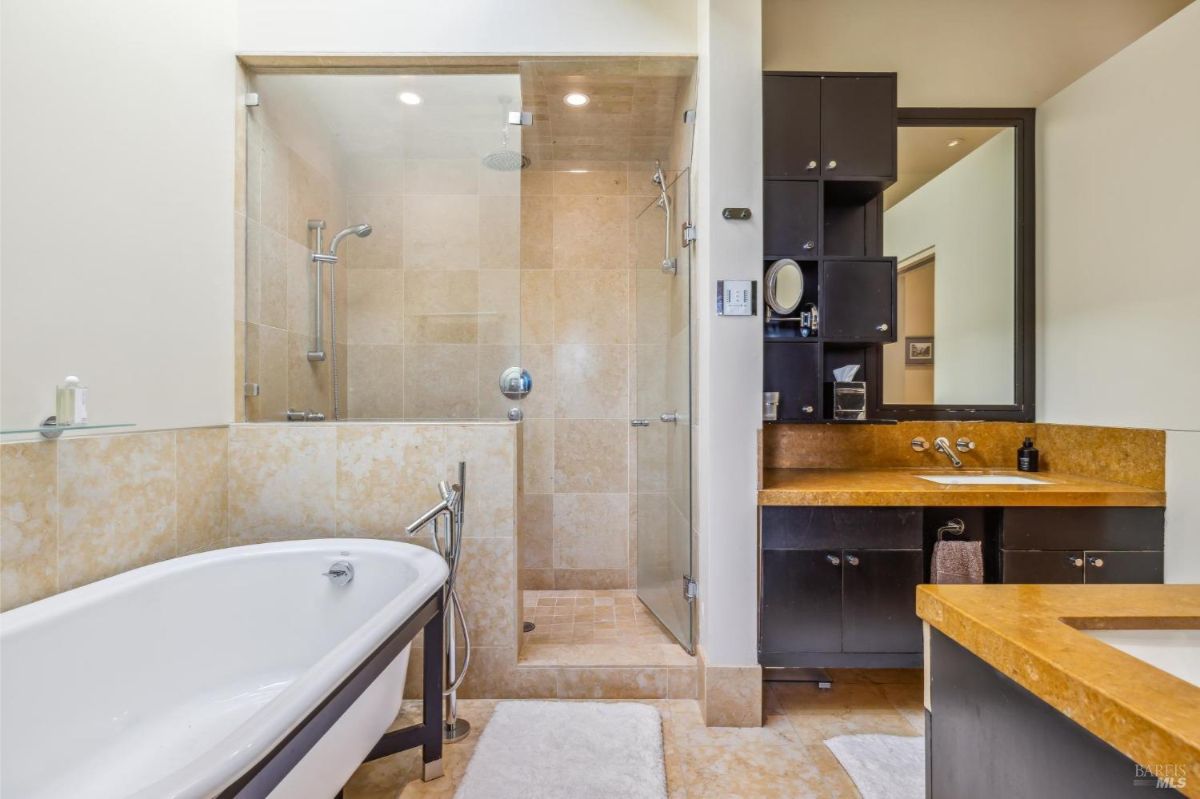 Luxurious bathroom with a freestanding tub, walk-in shower, and a marble finish.