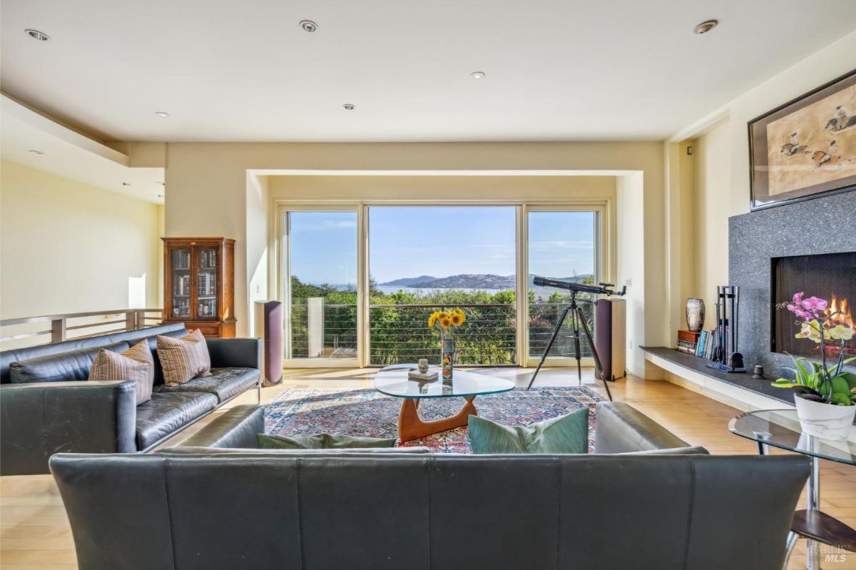 Living room featuring a large glass window with mountain views and a telescope.
