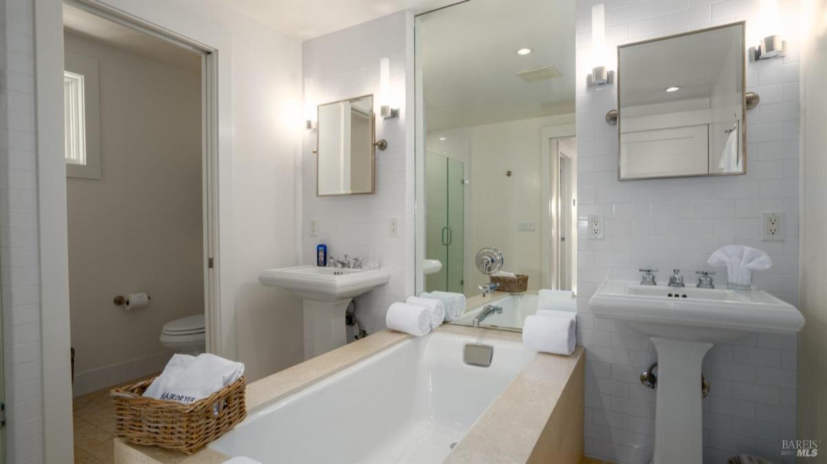 Bathroom with dual sinks, a bathtub, and a separate shower.