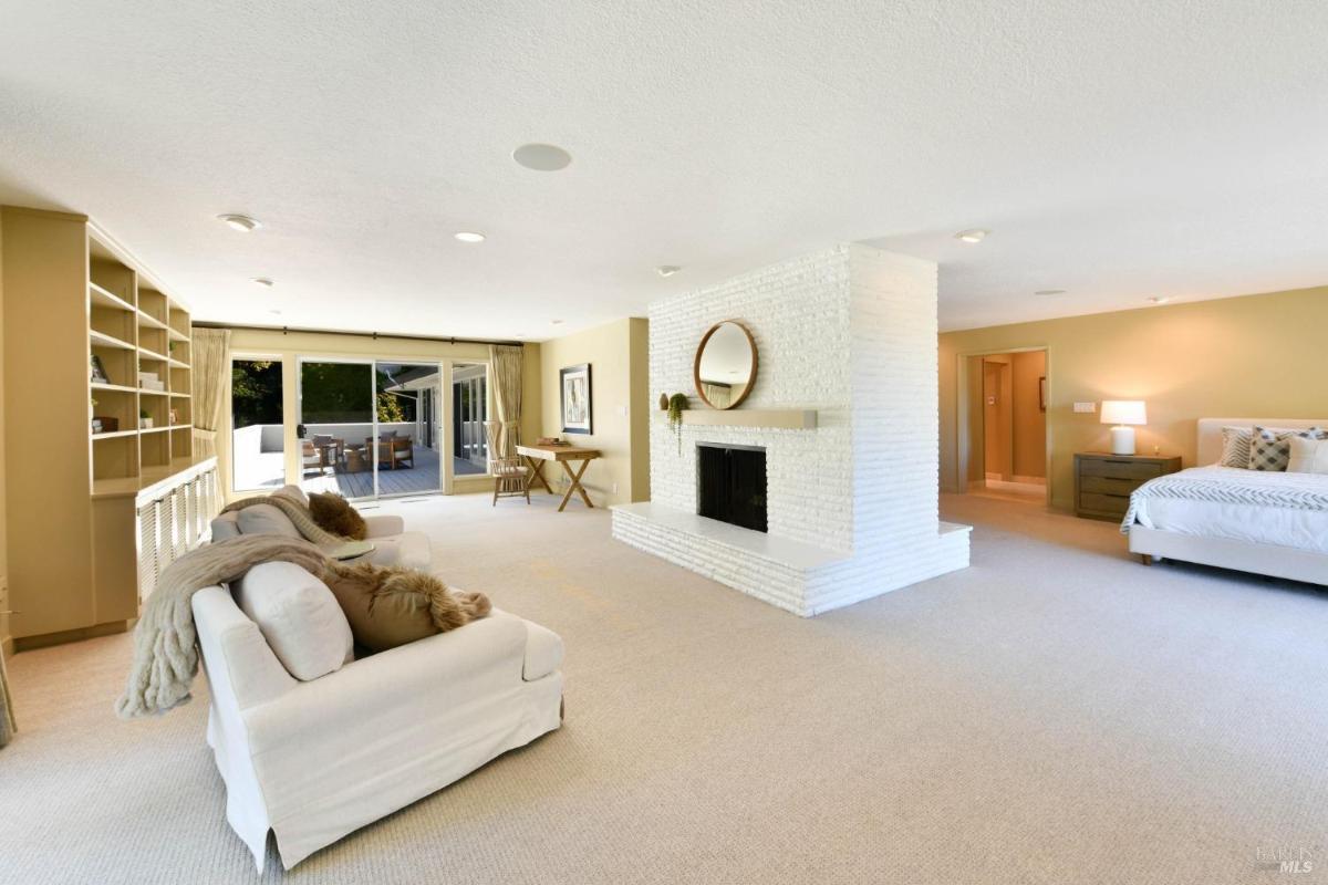 A sitting area with a white brick fireplace and access to a patio.