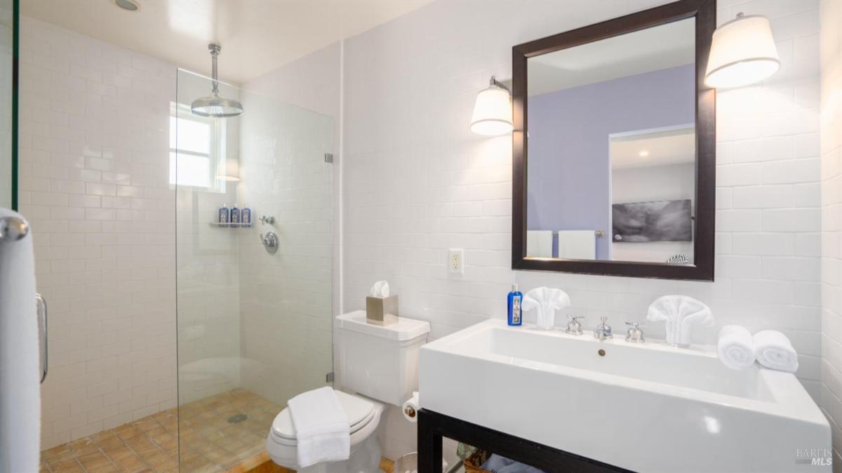 Bathroom with a glass shower, toilet, and single sink vanity.